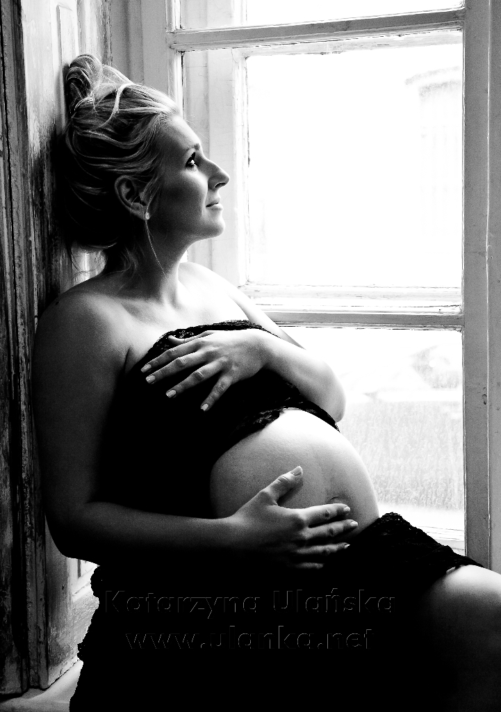 kobieta w ciąży siedząca przy oknie