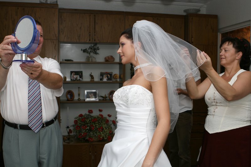 Fotografia ślubna - Przygotowania do ślubu, panna młoda z rodzicami przegląda się w lusterku