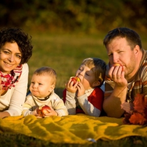 Fotografia rodzinna leżąca w parku na kocu