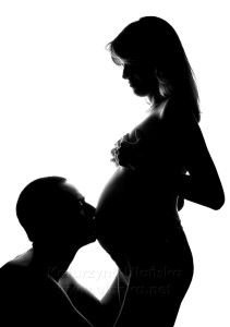 zdjęcia ciążowe, mężczyzna całujący brzuszek żony w ciąży