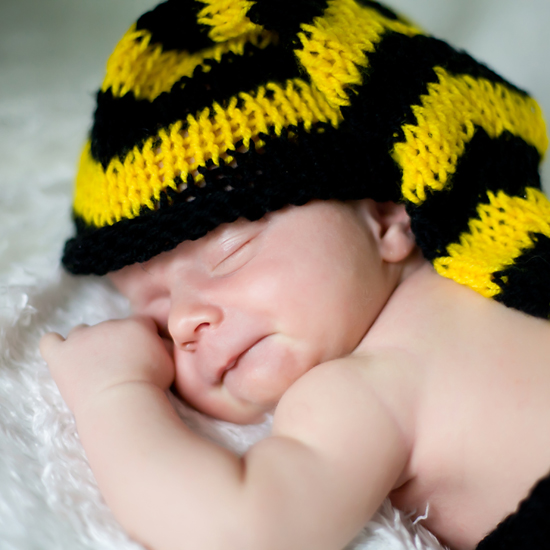 Śpiący malec w czarno żółtej czapce