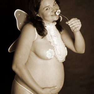 Fotografia ciążowa, kobieta w ciąży wąchająca kwiatek