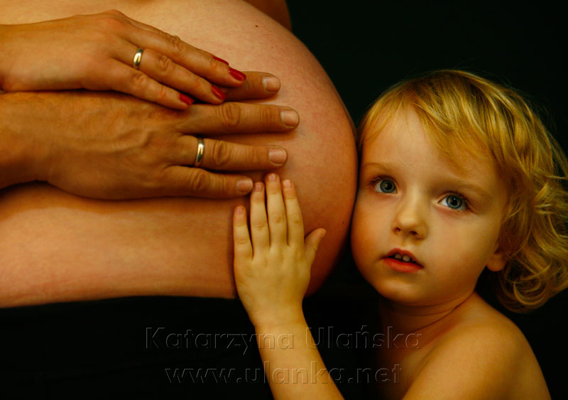 Fotografia ciążowa, mała dziewczyna słucha brzucha mamy