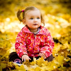 Dziewczynka bawiąca się w liściach