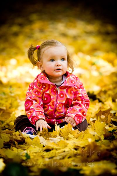 Dziewczynka bawiąca się w liściach