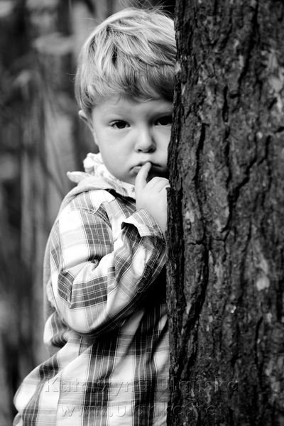 Fotografia chłopca za drzewem