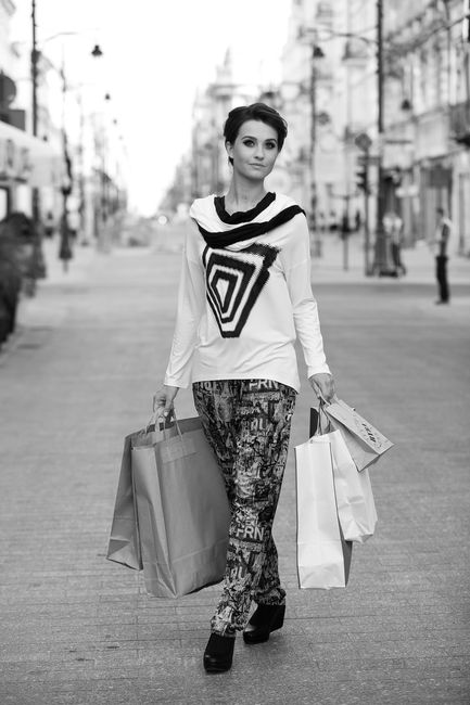 Fotografia mody, czarno białe zdjęcie pięknej modelki idącej z zakupami