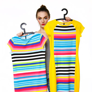 Moda, modelka trzymająca wieszaki z kolorowymi strojami