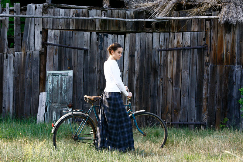 Fotografia mody, modelka przy rowerze na tle stodoły
