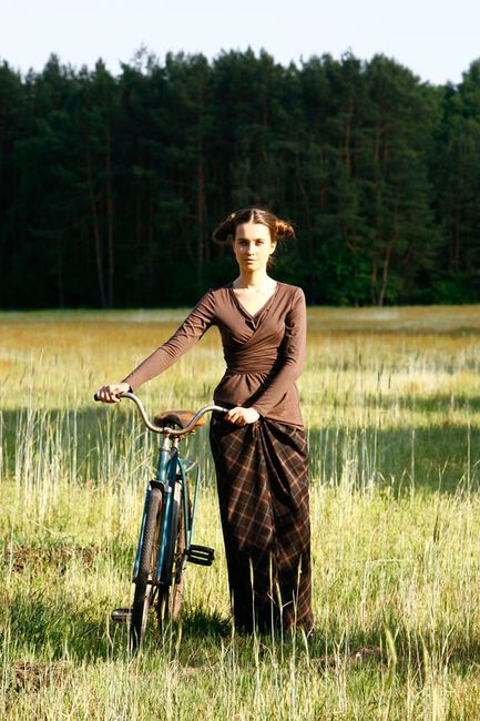 Fotografia mody, modelka spacerująca z rowerem na łonie natury