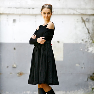 Fotografia mody, modelka w czarnym stroju na tle szarego muru