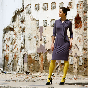 Fotografia mody, modelka w fioletowej sukience na tle starego muru