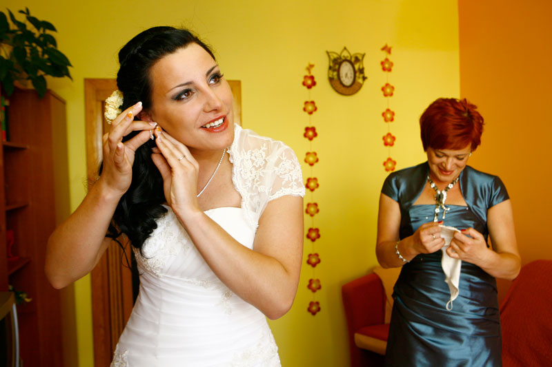 Fotografia ślubna - Przygotowania do ślubu, panna młoda zakładająca kolczyki
