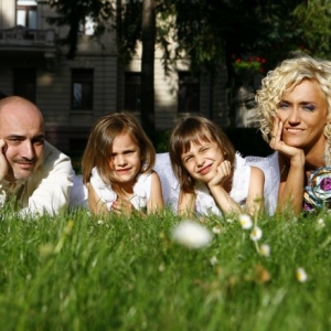 Fotografia rodzinna, zdjęcie uśmiechniętej rodziny leżącej na trawie