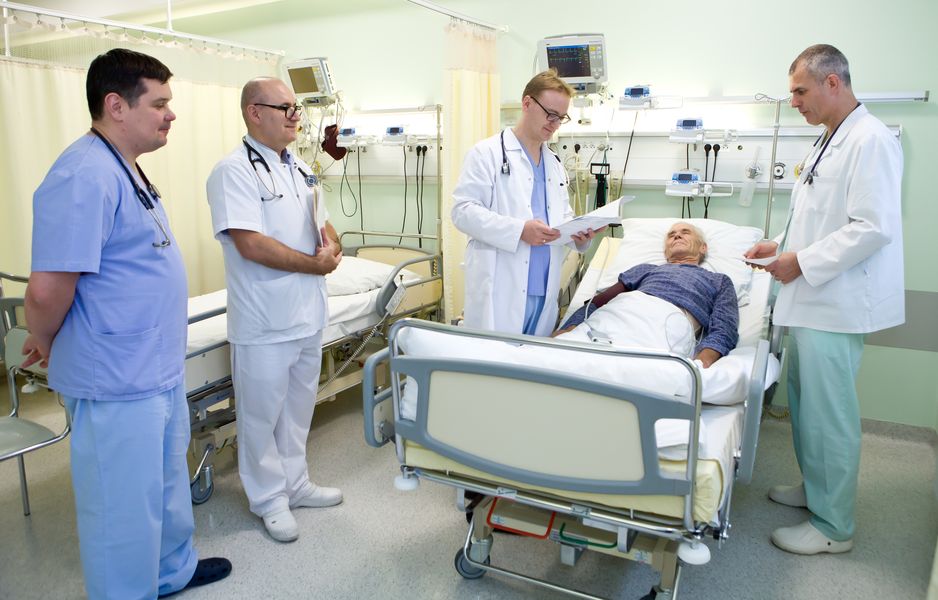 fotografia wizerunkowa kliniki, lekarze stojący przy łóżku pacjenta