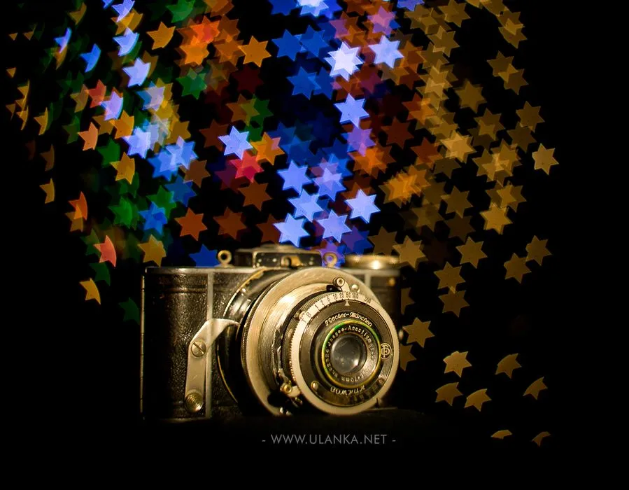 Efekt bokeh, stary aparat fotograficzny na tle efektu bokeh gwiazdki