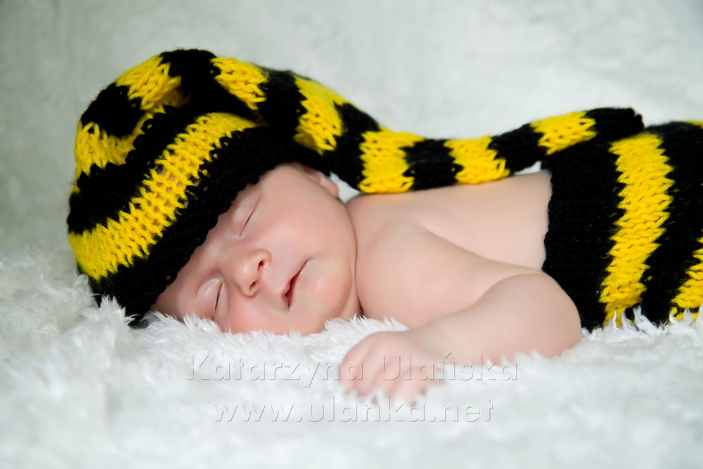 Śpiący noworodek w czapce pszczoły