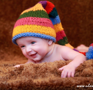 Śmiejący się maluszek w kolorowej czapce