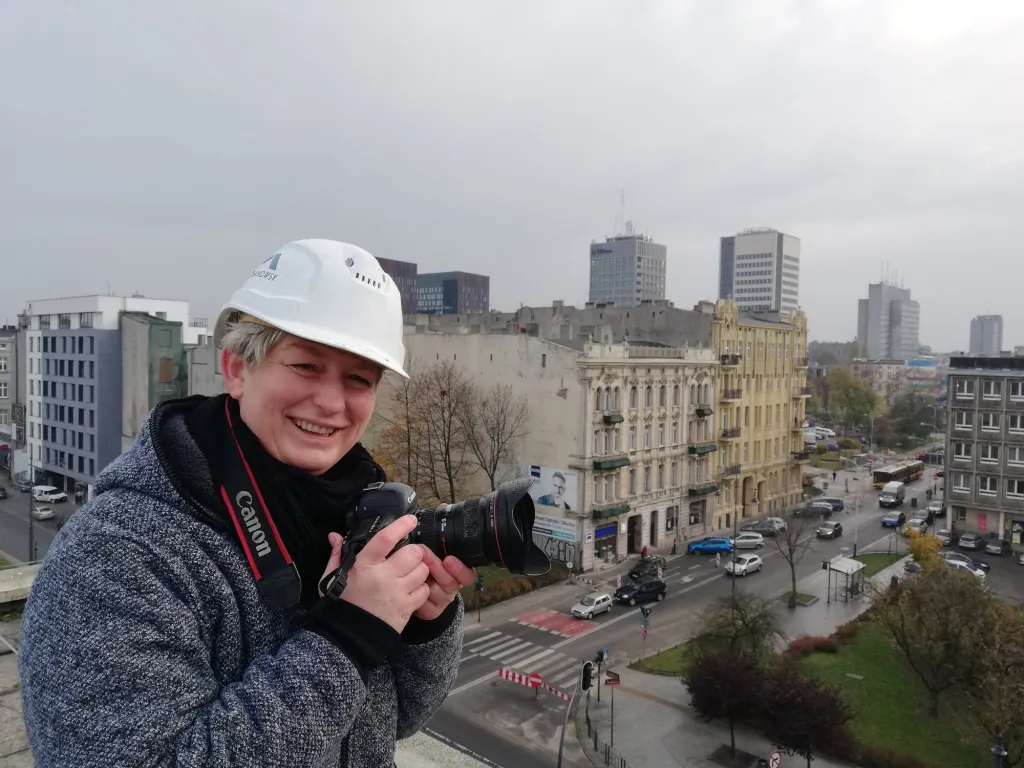 Katarzyna Ulańska, fotograf z Łodzi, z aparatem na dachu nad centrum miasta