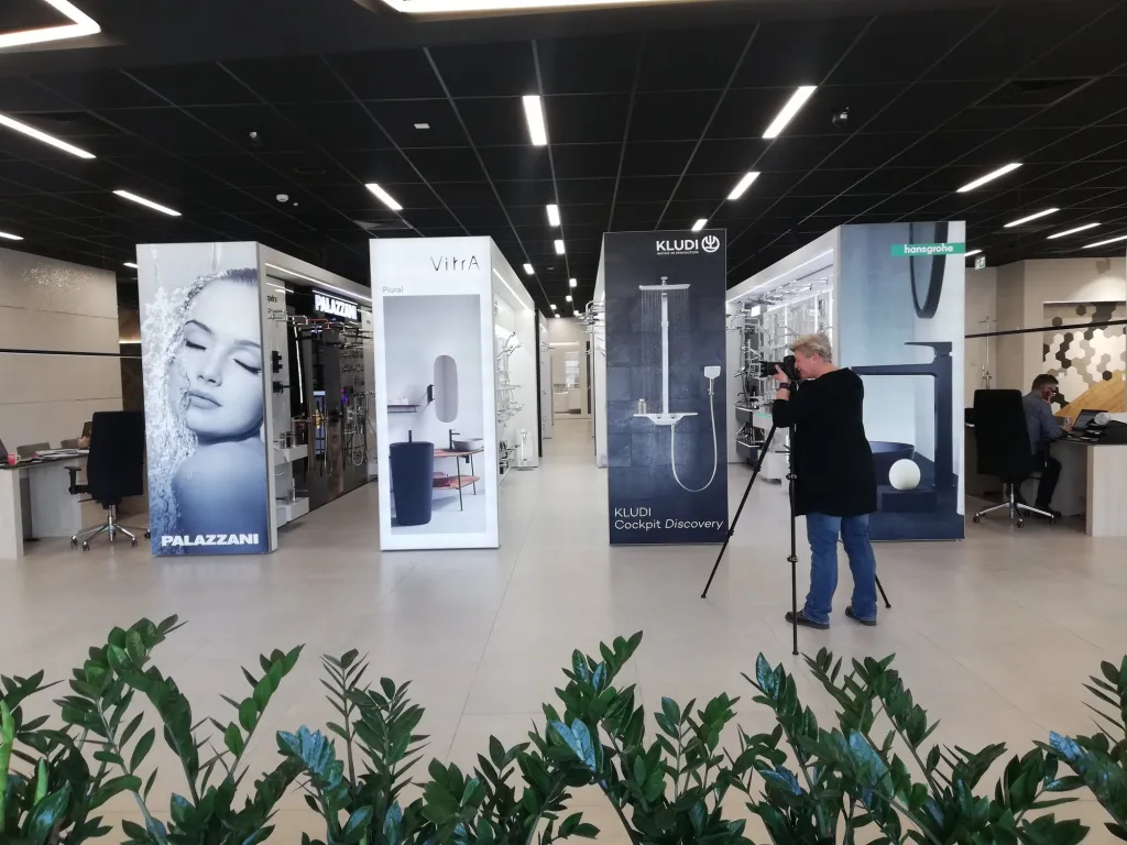 Fotografka ze statywem podczas sesji wnętrz w salonie firmowym