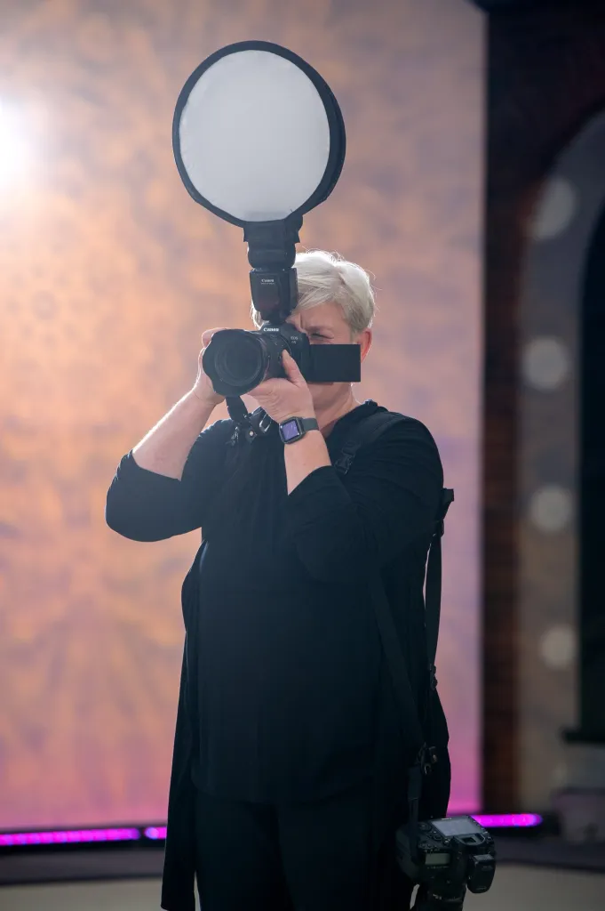 Fotografka z lampą błyskową podczas sesji w studiu