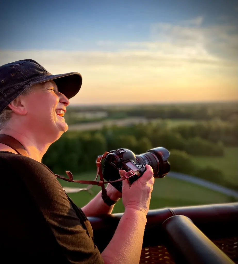 Fotografka z aparatem fotografuje zachód słońca