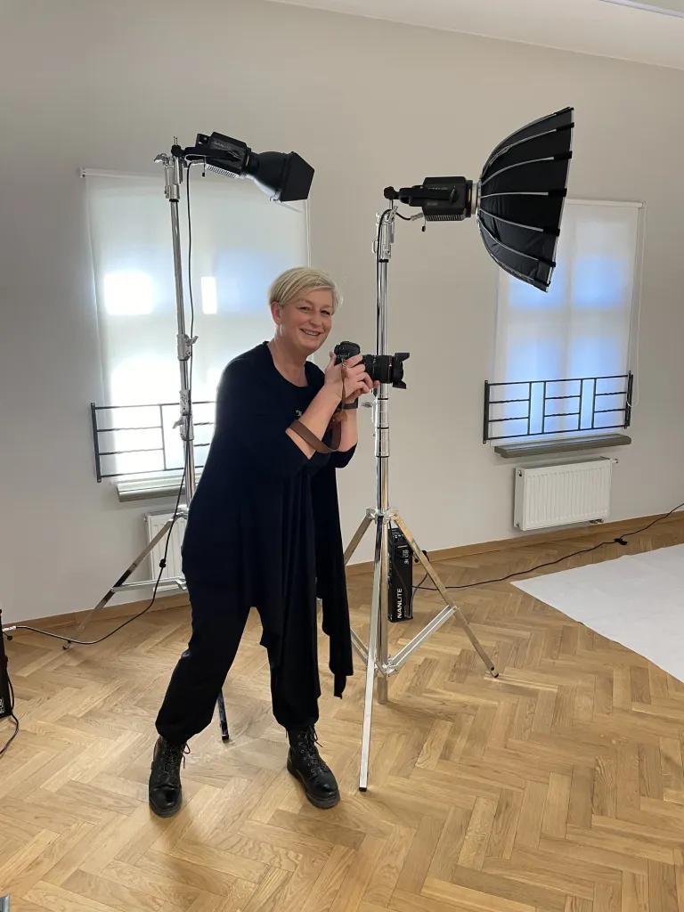 Fotografka z aparatem w studiu z lampami błyskowymi