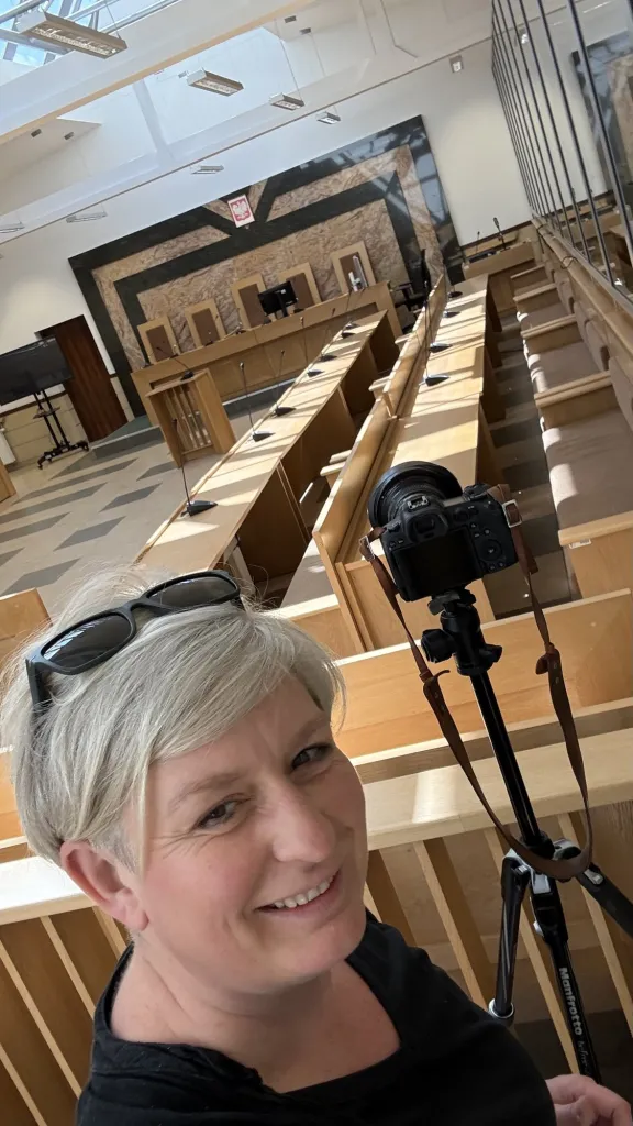 Fotografka z aparatem na statywie w sali konferencyjnej