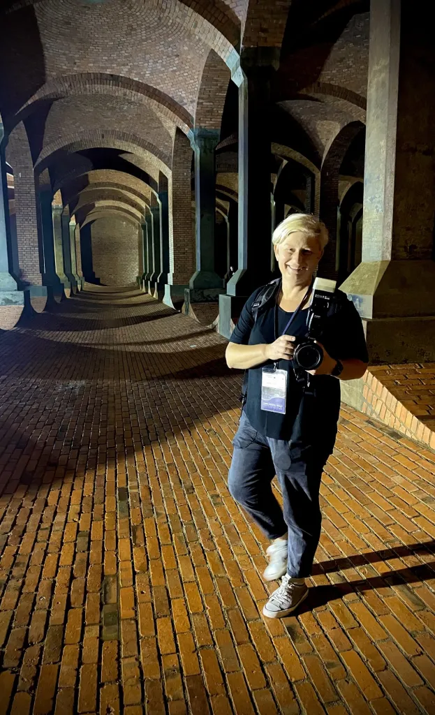 Fotografka z aparatem w zabytkowych arkadach