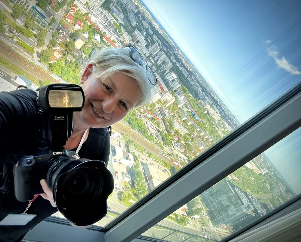 Selfie fotografki z aparatem na wysokim piętrze nad miastem