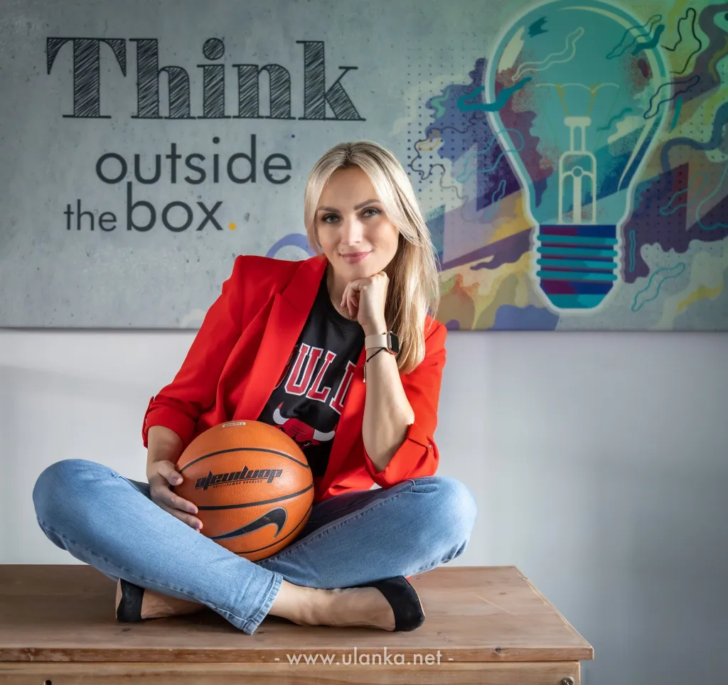 Sesja wizerunkowa kobiety z piłką na tle napisu Think outside the box