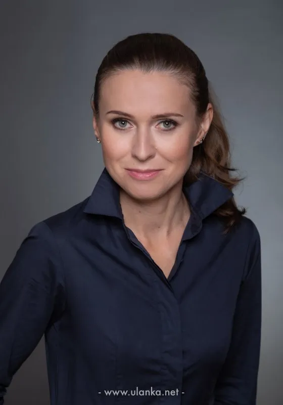 Portret biznesowy kobiety w ciemnej koszuli na szarym tle