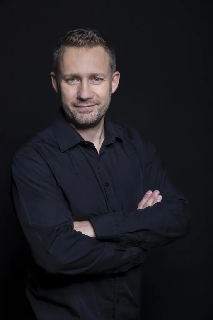 Portret biznesowy mężczyzny w czarnej koszuli na ciemnym tle