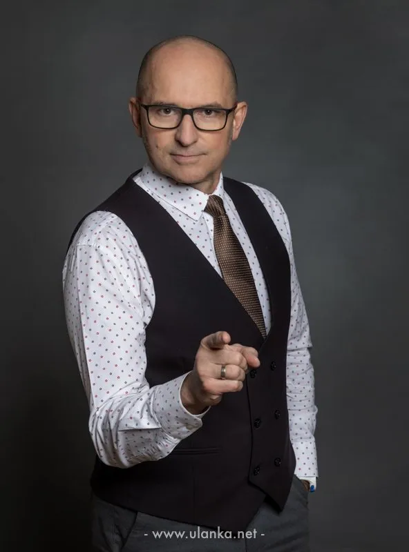 Portret biznesowy mężczyzny w kamizelce wskazującego w obiektyw