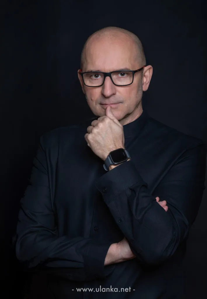 Portret biznesowy mężczyzny w okularach na ciemnym tle
