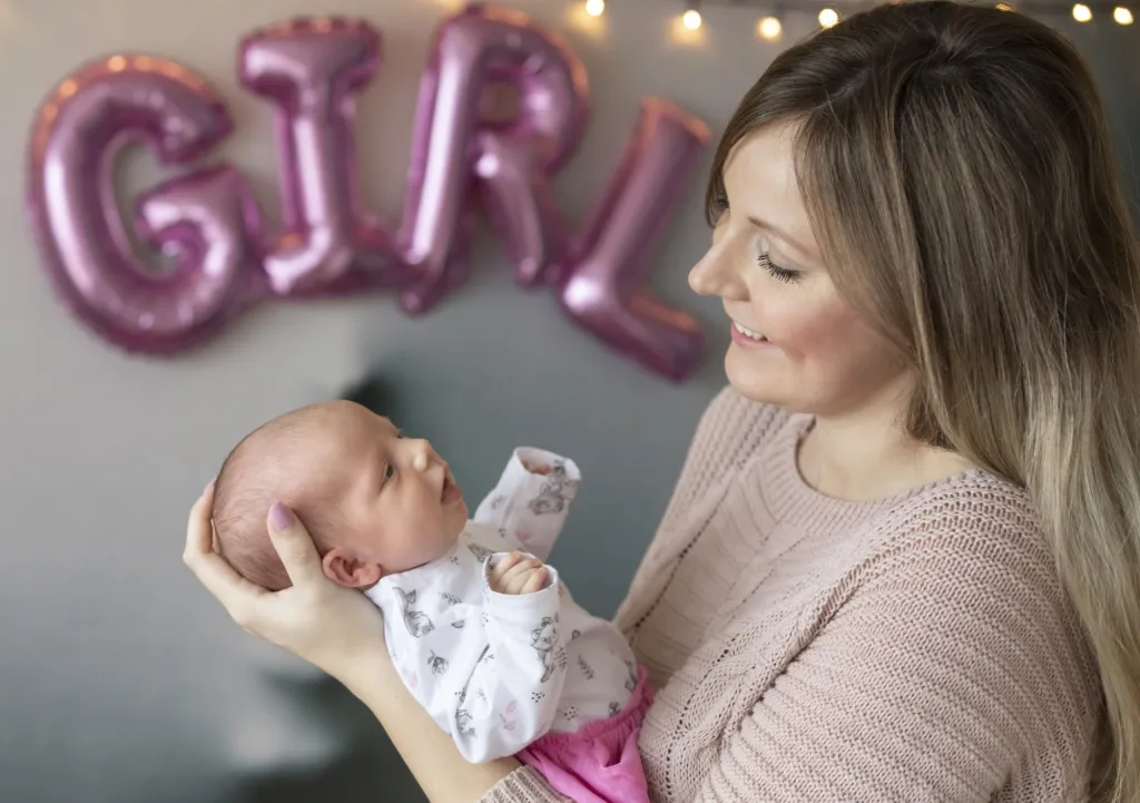 Sesja noworodkowa – mama z córeczką i balonem GIRL