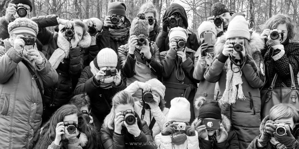 Grupa uczestników warsztatów fotograficznych z aparatami