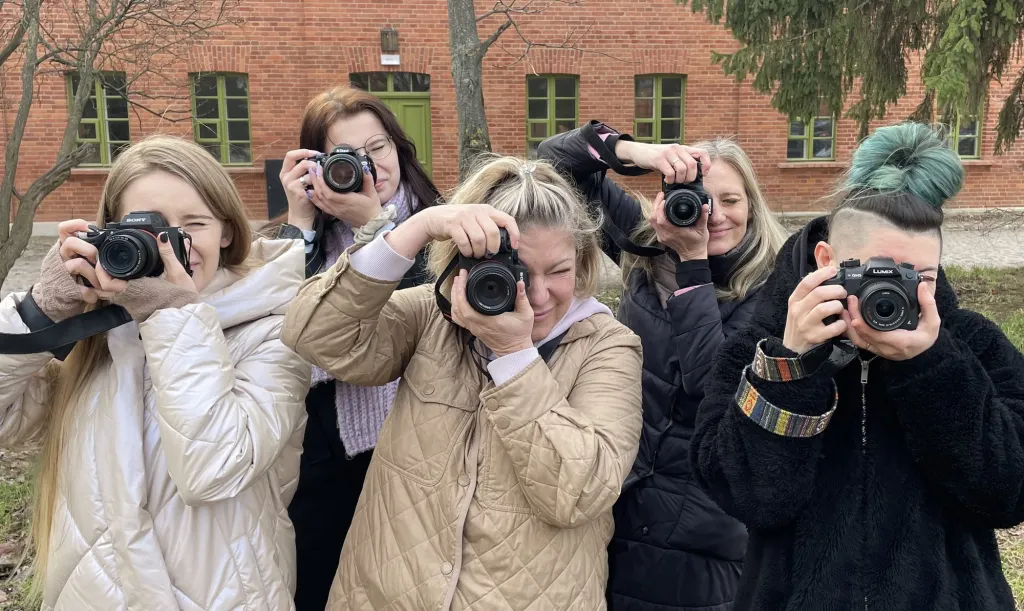 Uczestniczki warsztatów fotograficznych celują obiektywami w aparat
