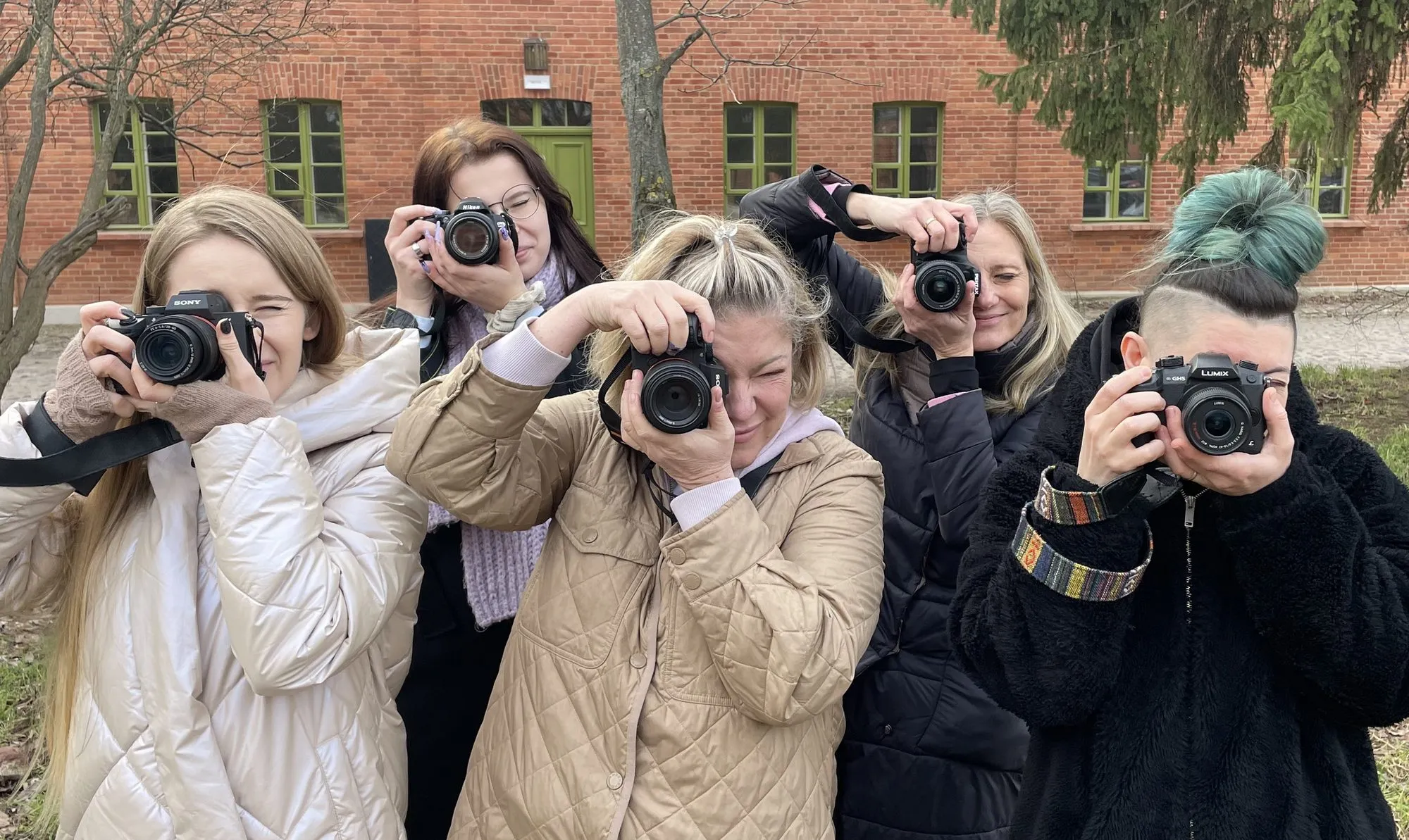 Uczestniczki warsztatów fotograficznych celują obiektywami w aparat